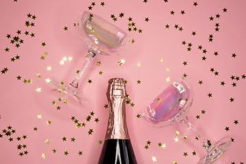 champagne coupes and bottle and confetti, flat lay, copy space