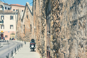 Obraz premium Unfocused or blurred motorbike on the narrow colorful mediterranean street in the Chania town. Island of Crete, Greece