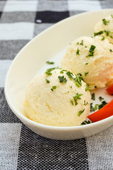Kaymak on a white plate with tomatoes and parsley