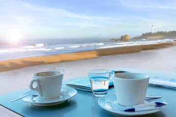Cup of coffee with a sweet cake and croissant. Concept of good morning, tasty breakfast in hotel outside on the terrace with sea view.