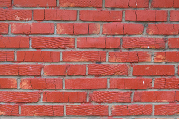 Background from a wall from a red brick. Bricks not uniform in a form. Some bricks with stamping of the drawing