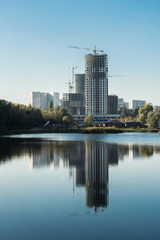 Fototapeta premium modern buildings with reflection in lake in city in autumn