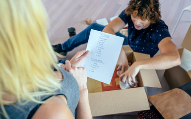 Couple unpacking moving boxes in their new house