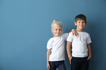 Boy and girl in t-shirts on color background