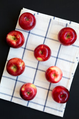 Fresh raw red apples on cloth on dark background, top view. Flat lay, overhead, from above. Close-up.