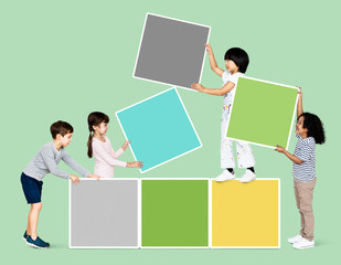 Fototapeta na wymiar Diverse happy kids stacking empty square boards