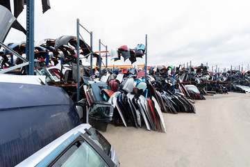 Obraz premium Auto parts market. On the ground are doors, bumpers and windshields.