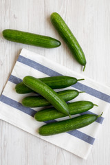 Fresh raw green cucumbers on white wooden background, top view. Flat lay, from above, overhead.