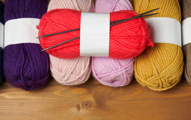 colorful wool yarn for knitting on wooden background