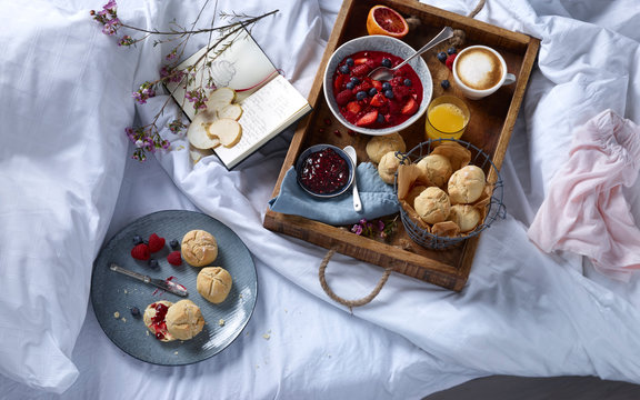 Wooden tray with breakfast on bed
