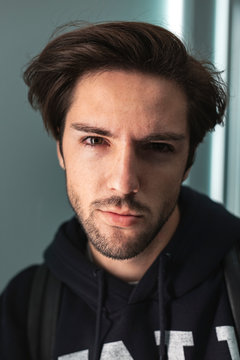 Close up portrait of handsome confident young man looking at camera wearing sweatshirt