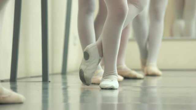 Ballerinas feet in pointes. Legs of ballet girls having practice at class. Element of classical dance exercise.
