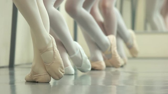 Legs of ballet girls in pointes. Faceless girls leg in ballet shoes making position on the floor. Legs position in ballet.
