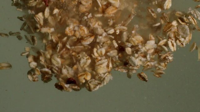 Whole grain cereal muesli in a bowl for a morning delicious breakfast with milk. Slow motion with rotation tracking shot.