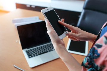 beautiful businesswoman model post using cell phone with labtop computer