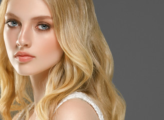 Blonde woman face closeup with healthy skin and beauty makeup