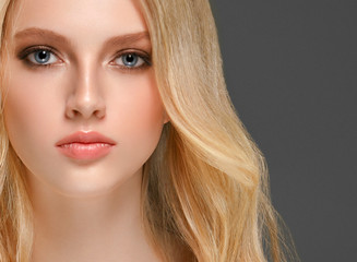 Blonde woman face closeup with healthy skin and beauty makeup
