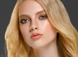 Blonde woman face closeup with healthy skin and beauty makeup