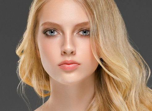 Blonde woman face closeup with healthy skin and beauty makeup