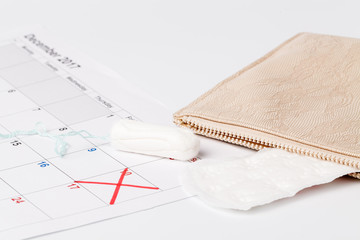 Planning pointing at date in calendar with menstrual  tampons concept