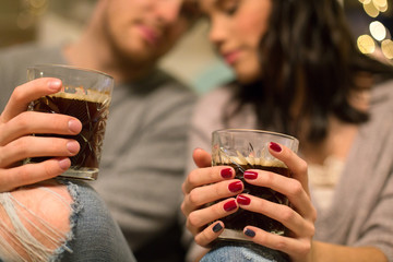hygge, leisure and people concept - close up of happy couple drinking coffee at home