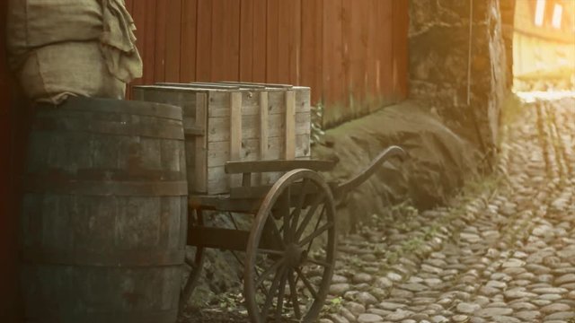 Old style, trolley and barrels traditional. Pavement sidewalks, vintage, retro style historical farm concept. Sunlight and shine.
