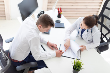 Obraz premium The young man at the doctor's office signs the documents.