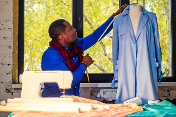 portrait of a handsome african man seamstress with sewing machine.Afrio American man stylish...