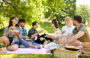friendship, leisure and fast food concept - group of happy friends eating sandwiches or burgers at...