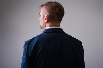 Studio shot of blonde businessman wearing blue suit