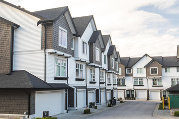 Brand new townhouses with concrete pavement in front. Front side of townhouses on sunny day in Canada.
