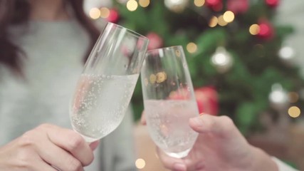Slow motion - Group of cheerful happy young Asian woman holding and drinking glasses of champagne in christmas party at home. Lifestyle women celebrate Christmas and New year concept.