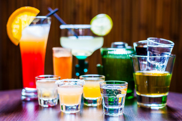 Selection of colorful drinks, alcoholic beverages and cocktails in different glasses on a table