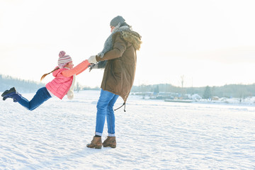 Vater lässt seine Tochter fliegen im Winter