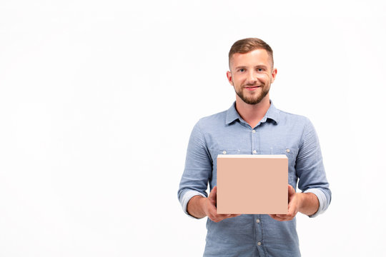 Casual Young Man Holding A Box Isolated On A White Background