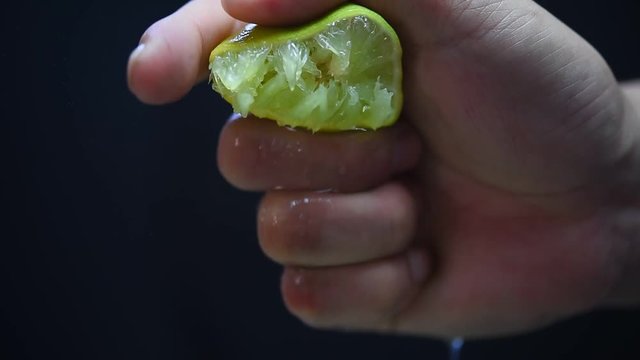 Hands are squeezed lemon black backdrop.