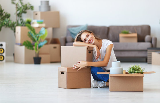 happy   girl with boxes moves to new apartment