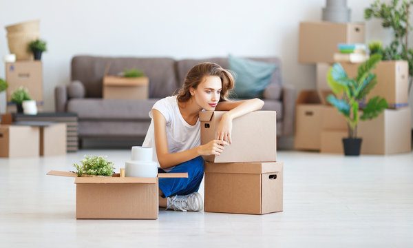 happy   girl with boxes moves to new apartment