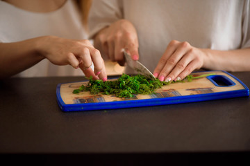 Young sisters making vegetable salad at home