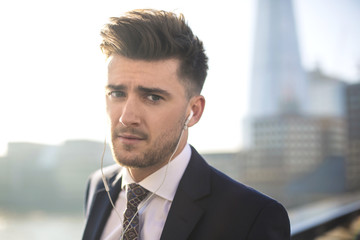 Handsome businessman listening something with earphones