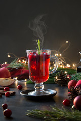 Christmas cranberry and apple mulled wine garnish rosemary and fir branches on black. Xmas drink.