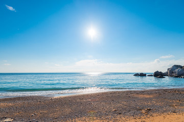 A bright midday sun over clear sea water, a view of the horizon. Seascape