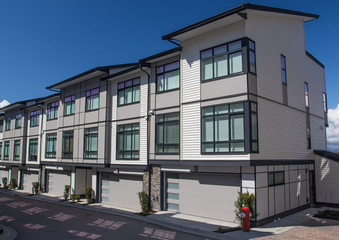 Nice development of new townhouses. External facade of a row of colorful modern urban townhouses.brand new houses just after construction on real estate market