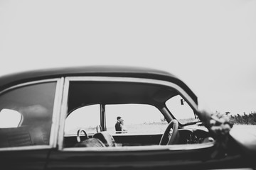 Just married couple in the luxury retro car on their wedding day