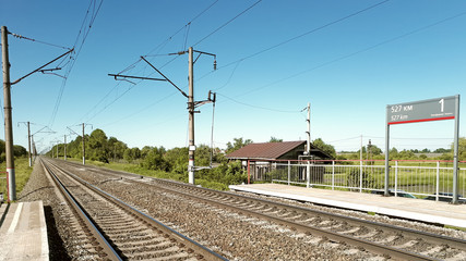 Panoramic landscape rural summer view on electrified railroad 2 way track with small station platform named 527 km in central europe russia landmark transportation train travel tourism vacation scene