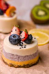 Cake with fruits and berries close-up. White dessert on a wooden table.