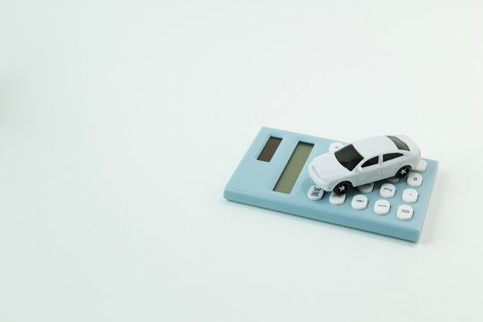 white car toy and blue calculator white background..