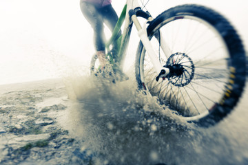Mountain Biker Racing Through Puddle