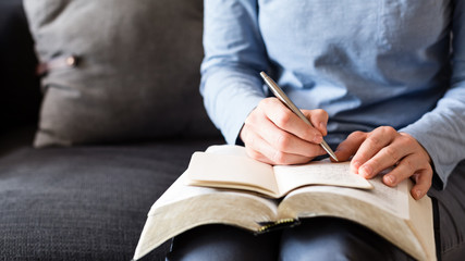 Bible Study - Woman Taking Notes as She Reads from an Open Bible - 230409085