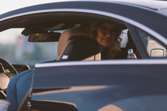 Photo of woman in sunglasses in car